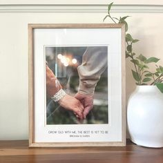 two hands holding each other in front of a white vase