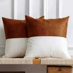 two brown and white pillows sitting on top of a wooden shelf next to wicker baskets