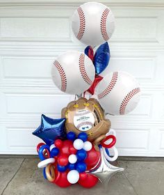 an arrangement of balloons and baseballs in front of a garage door