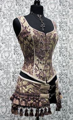 A Shrine classic!! A heavily constructed corset top in rich purple and ivory tapestry fabric with a great form fit. Heavy metal boning at sides and lycra stretch panel at back adds extra strong support. Fastens in front with seven large kilt pins but also zips in back for easy access. Rich ivory Decopunk Aesthetic, Gothic Costume, Ren Fair, Waist Trainers, Kilt Skirt, Bodice Top, Tapestry Fabric, Text Print, Rich Purple