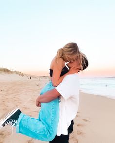 a man holding a woman on the beach