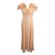 Elegant Peach Silk Chiffon Art Deco Pleated Edge Trimmed Gown from the 1930's. Pleated trim is used to edge the cape collar, sleeves and create neckline flowers. Hook and eye closure at neck with pleated detail down front. Full bias skirt. Gown is sheer. 1930's USA. Small size 2-4. Bust 32", Waist 26", Hip 36". 1stdibs Dress, Cape Collar, Bias Skirt, Art Deco Stil, Silk Gown, Silk Chiffon, Vintage Dresses, Evening Dresses, Cape