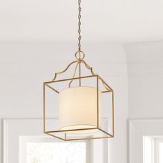 a chandelier hanging from a ceiling in a room with white walls and windows