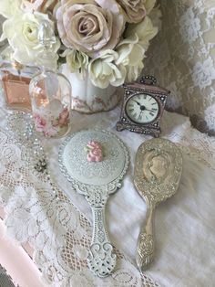 there is a vase with flowers and an antique clock on the table