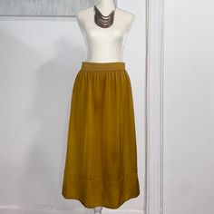 Dark Yellow Knee-Length Skirt In Satin With A High Waist, Elasticized Waistband, And Side-Seam Functional Pockets. Unlined And Never Worn. Has Some Threading Pulls As Pictured. 100% Polyester. Necklace Not Included. Elegant Long Yellow Skirt, Elegant Yellow Maxi Skirt, Gold Lined Maxi Skirt For Summer, Elegant Flowy Yellow Skirt, Elegant Yellow Flowy Skirt, Gold Flowy Long Skirt, Yellow Pleated Workwear Skirt, Yellow Flared Workwear Skirt, Yellow Pleated Skirt For Work