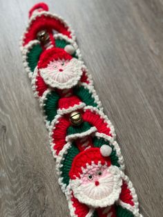 a crocheted santa clause belt with bells on the bottom and green and red trim