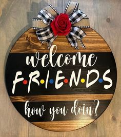 a wooden sign that says welcome friends how you doin? with a red rose on it