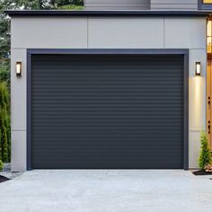 a grey garage door is open in front of a house with two lights on it