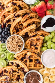 waffles, fruit and chocolate are arranged on a platter for a snack