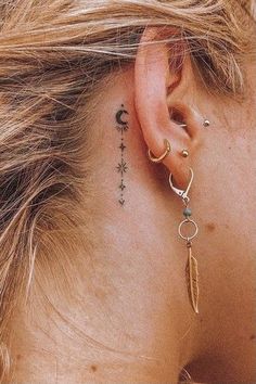 a close up of a person with a tattoo behind their ear