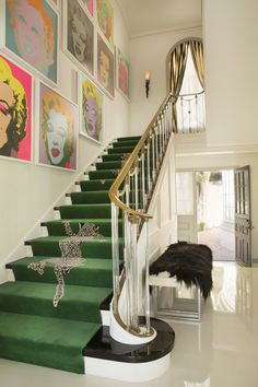 a green staircase with pictures on the wall