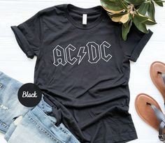 Rock'n Roll Shirt, ACDC Shirt, Rock Band Shirt, Rock Music Shirt, Rock Shirt Gift, ACDC Gift, Thunderstruck, Back In Black, Gift for Rocker Please check Shirt and Sweatshirt sizes carefully.. Hi! Welcome to YiYuTee store, I'm so happy to see you here. My store's main goal is to make you happy. Sweatshirt Details: This soft sweatshirt has a loose fit for a comfortable feel. With durable print, it will be a walking billboard for years to come. 50% Cotton Made by specially spinned fibers that make very strong and smooth fabric, perfect for printing. 50% Polyester Polyester fibers are extremely strong, resistant to most chemicals, stretching and shrinking. Viscose adds amazing draping and softness to the shirt. Machine wash: warm (max 40C or 105F); Non-chlorine: bleach as needed; Tumble dry: m Rock And Roll Shirt Ideas, Black Cotton Rock And Roll T-shirt, Unisex Rocker T-shirt For Concerts, Rock Band Logo T-shirt Relaxed Fit, Rock Band Logo T-shirt In Relaxed Fit, Rock Style Band Logo T-shirt With Relaxed Fit, Rock Style Band Logo T-shirt In Relaxed Fit, Rock Style Band Logo T-shirt For Summer, Rock And Roll Black Cotton T-shirt