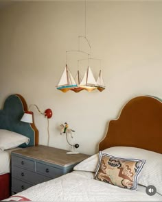 a bedroom with two beds and a lamp hanging from the ceiling