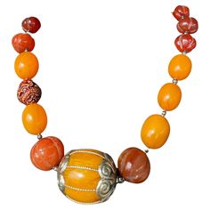 Tribal style vintage Bakelite and Amber beads Comprise this handmade, one of a kind necklace.A fabulous center bead of Indian amber with silver end caps is flanked by vintage Tibetan gourd shape carved carnelian beads. A vintage carved nut bead creates asymmetry and visual interest. Silver spacers are used between the Bakelite beads. This unusual and stunning piece will create drama wherever it goes! The Bakelite beads come from a vintage necklace that I found out West. Don’t miss out on this wa Vintage Amber Beads, Gems, And Cabochons, Vintage Amber Beaded Gems And Cabochons, Vintage Amber Polished Beads, Gems, And Cabochons, Vintage Amber Gemstone Beads, Vintage Carnelian Beaded Necklace, Vintage Amber Carnelian Beads Gems And Cabochons, Vintage Beaded Carnelian Necklace, Vintage Orange Beads, Gems, And Cabochons For Gifts, Vintage Orange Beaded Necklaces With Oval Beads