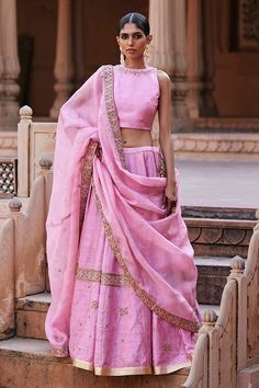 Baby pink flared raw silk lehenga with canna bloom zardozi embroidery adorned with spluttered sequin highlights. Paired with a sleeveless halter neck pure silk blouse with intricate floral vine embroidery on the neckline and organza dupatta adorned with floral garden hand embroidered zardozi borders. - Aza Fashions Pink Raw Silk Sharara For Festivals, Pink Raw Silk Pre-draped Saree With Resham Embroidery, Pink Silk Sets With Dori Work, Pink Raw Silk Sharara With Gota Work, Pink Raw Silk Sharara With Zari Work, Pink Raw Silk Sharara For Navratri, Pink Raw Silk Pre-draped Saree With Dupatta, Pink Raw Silk Set With Sheer Dupatta, Pink Raw Silk Sharara With Traditional Drape