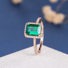 an emerald colored ring with diamonds on it