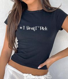 🏈 Show off your love for all things sports with our "#1 Draft Pick!" crop top! This fun and stylish baby tee is perfect for game day, whether you're cheering from the stands or hanging out with friends. Inspired by Y2K and 90s fashion, it's a must-have for any sports fan looking to add a cute and playful touch to their wardrobe. If you have any questions about this listing please feel free to send me a message. I can customize most items so feel free to ask. SIZING CHART: These shirts are unise Casual Fitted T-shirt For Game Day, Sporty Black Crop Top T-shirt, Casual Crew Neck Crop Top For Sports, Trendy Sports Cropped T-shirt With Crew Neck, Casual Sports Crop Top With Letter Print, Cotton Graphic Print Crop Top For Sports, Sporty Slogan Tops For Streetwear, Casual Graphic Print Crop Top For Sports, Sporty Logo Print Crew Neck Crop Top