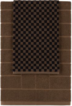 a black and brown checkered wall hanging on a brick wall