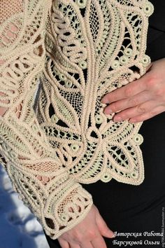 a close up of a person wearing a lacy crochet shawl with her hands on her hip