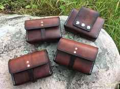 four brown leather cases sitting on top of a rock