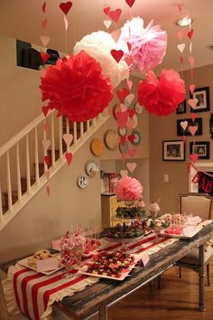 valentine's day table with paper hearts hanging from the ceiling