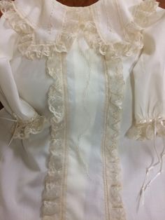 This beautiful baby gown has a centered row of hand embroidery framed by gathered French val or Maline lace edging The collar has a unique tabbed shape with hand embroidery on the tab and gathered French val or Maline lace edging The hem is finished with flat French lace. Buttons in back Add a bonnet, diaper cover, and burp clots for a complete ensemble! Just perfect! Hand wash cold; dry flat Classic White Gown With Lace Trim, Classic Baptism Gown With Lace Trim, Formal Baptism Dress With Lace Ruffles, Formal Lace Baptism Dress With Ruffles, Cream Ruffled Gown For Baptism, Elegant Baptism Dress With Lace Trim For Daywear, Elegant Baptism Dress With Lace Trim, Cream Baptism Dress With Ruffles, Cream Baptism Dress With Ruffles For Ceremony