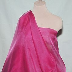 a mannequin wearing a pink dress with one shoulder draped over the other,