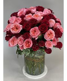 a vase filled with red and pink roses