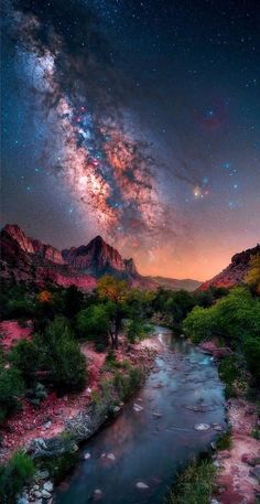 the night sky is filled with stars above a river and mountain range in the distance