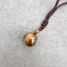 Discover the beauty, symbolism, and versatility of the Stone Sphere Rope Necklace as it becomes a unique expression of your style and connection to the energy of natural gemstones. Spheres are symbolic of completeness, unity, and the cyclical nature of life. The stone sphere on this necklace serves as a reminder of the interconnectedness of all things and the continuous flow of energy. The rope necklace is suitable for both everyday wear and special occasions. Its adjustable design and natural e Spiritual Obsidian Jewelry With Natural Stones, Adjustable Spiritual Obsidian Jewelry, Spiritual Obsidian Jewelry For Meditation, Bohemian Obsidian Jewelry For Healing, Smoky Quartz Pendant Necklace Gift, Smoky Quartz Pendant Necklace For Gift, Round Crystal Amulet Necklaces For Meditation, Amber Crystal Pendant Necklace For Meditation, Amber Pendant Crystal Necklace For Meditation