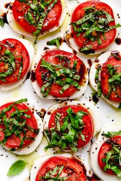 an assortment of tomatoes and mozzarella on a white platter