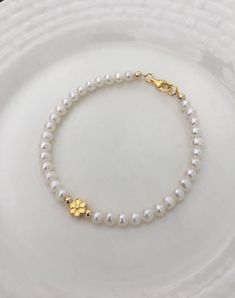 This elegant freshwater pearl bracelet features a beautiful flower charm, The charm and clasp are made of 925 Sterling Silver or 18K gold plated  Sterling Silver. If you need an extender chain, you can leave a note in the order. Elegant Beaded Bracelets With Flower Charm And Round Beads, Elegant Beaded Bracelets With Flower Charm, Elegant Gold Beaded Bracelet With Flower Charm, Delicate Yellow Gold Pearl Bracelet With Charm, Adjustable Gold Pearl Flower Bracelet, Gold Pearl Flower Bracelets, Gold Flower Pearl Bracelet For Wedding, Dainty Gold Flower Pearl Bracelet, Flower Charm Bracelet