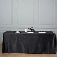 a black table with two wine bottles on it and one empty bottle in the middle