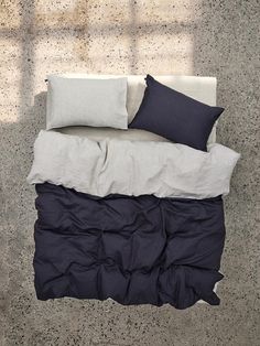 an overhead view of a bed with pillows and blankets on top of it in a room