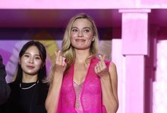 a woman in a pink dress standing next to another woman