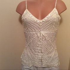 a woman's white tank top with crochet details