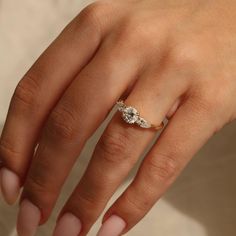 a woman's hand with a diamond ring on her left hand and two diamonds on the middle finger