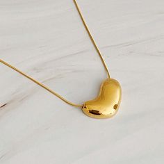 This Bold Molten Heart Necklace is as stylish as it is eye-catching. Featuring an impressive dimensionally rounded heart pendant hung on a round herringbone chain, it is sure to make any outfit stand out. Material Composition: 18k gold plated stainless steel, water and tarnish resistant Lead and Nickel free Imported Modern Gold Necklace With Heart Pendant, Modern Gold Heart Pendant Necklace, Trendy Heart-shaped Gold Plated Necklaces, Trendy Gold Plated Heart Pendant Necklace, Trendy Gold Plated Heart Necklaces, Gold Heart Pendant Necklace Trendy, Trendy Gold Heart Pendant Necklace, Trendy Gold Plated Heart Necklace, Trendy Yellow Gold Heart Necklace