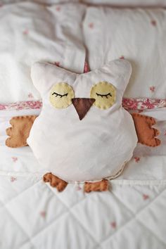 an owl pillow is laying on the bed