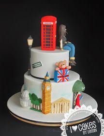 there is a cake decorated with the british symbols and people sitting on top of it