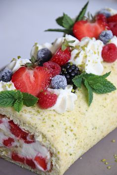 a piece of cake with berries and whipped cream on top