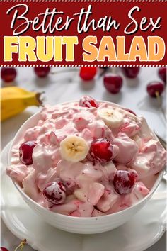 a bowl filled with fruit salad on top of a white plate next to bananas and cherries