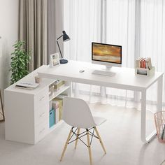 a desk with a computer on it in front of a window