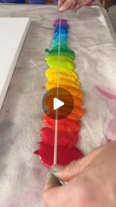 someone is making a rainbow streamer out of melted paint