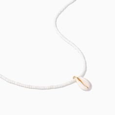 a white necklace with a shell hanging from it's side on a string that has a gold clasp