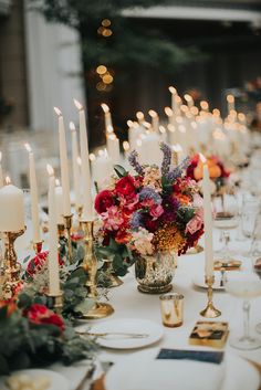 a table topped with lots of candles and flowers