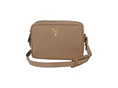 This crossbody bag is crafted with beige vitello phenix leather. The bag features a gold Prada Milano logo on the front and an adjustable leather strap. The two zipper compartments open to a spacious jacquard lined interior that allows for convenient storage and organization. This Prada handbag is great for everyday use with the distinctive quality and style of Prada!    Model: 1BH079  Cammeo Beige Vitello Phenix Grain Leather  Gold-tone Hardware  Prada Milano Logo  Zipper Closure  Two Zipper Co Luxury Crossbody Bag With Logo Plaque, Rectangular Travel Bag With Logo Plaque, Gold Crossbody Bag With Logo Plaque, Leather Crossbody Bag With Logo Plaque, Business Crossbody Shoulder Bag With Logo Plaque, Luxury Shoulder Bag With Logo Plaque For Travel, Luxury Travel Shoulder Bag With Logo Plaque, Modern Travel Bags With Logo Plaque, Luxury Logo Plaque Shoulder Bag For Travel