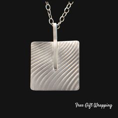 "Experience the striking allure of our Argentium Silver Square Bar Abstract Necklace. This piece is not just a necklace, it's a statement - a testament to the beauty of handcrafted art. Each square has a beautifully textured wave design and the bar that connects them are meticulously fashioned from high-quality Argentium silver, known for its bright white color, hypoallergenic properties, and resistance to tarnish. The abstract design exudes a modern aesthetic that plays wonderfully with light, Argentium Silver Jewelry, Silver Cuff Ring, Unique Sterling Silver Jewelry, Abstract Necklace, Handmade Silver Jewellery, Square Bar, Fluid Design, Geometric Bracelet, Silver Gift Box