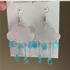 a pair of earrings with blue glass drops hanging from them