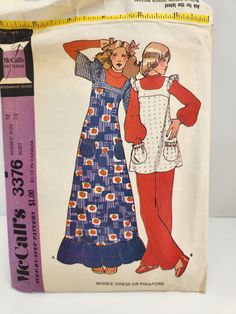 This is a vintage pattern from the 1970s. It is a dress sewing pattern. It is for a size 12 and measures up to a 34 inch bust. The description reads: This dress or pinafore has tilted yokes, armhole ruffles, patch pockets gathered by elastic in casing. Ruffled dress version A features sleeves and back vent, on pinafore version B with open back have fabric bows.  The pattern is uncut, comes with complete instructions, and the original envelope. 70s Long Dress, Long Dress Pattern, Pinafore Sewing Pattern, 70's Dress, 70s Sewing Patterns, Long Dress Patterns, 1970s Sewing Patterns, Patron Vintage, 1970s Women